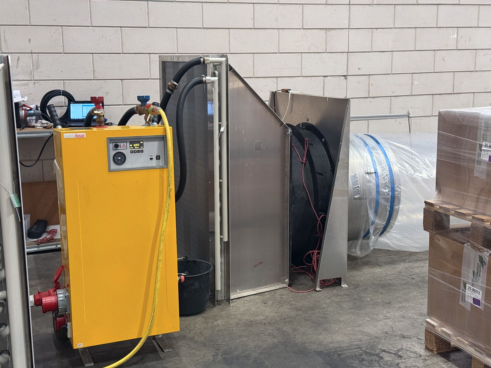 The AHU test setup in the hall: coil block, fan and hose